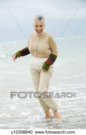 A senior woman on a beach View Large Photo Image Stock Image - A senior woman on a beach. Fotosearch