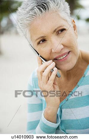 Stock Image - A senior woman using a mobile phone. Fotosearch