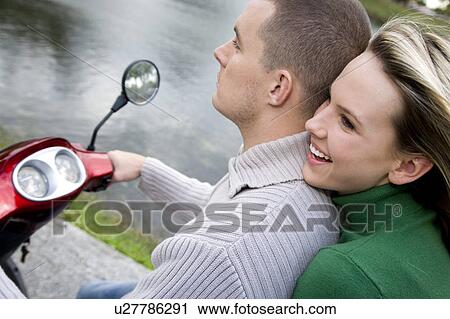 Stock Image - A young couple on a scooter. Fotosearch