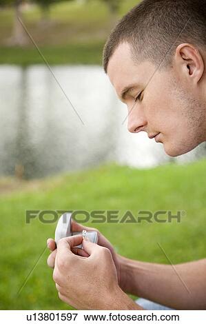 A young man holding an engagement ring View Large Photo Image Stock Photo - A young man holding an engagement ring. Fotosearch