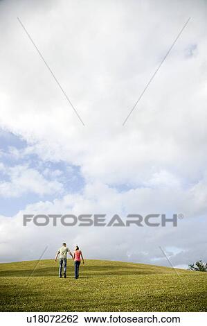 Stock Image - Two young lovers holding hands. Fotosearch