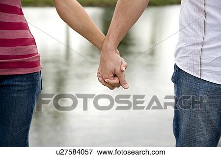 Two young lovers holding hands View Large Photo Image Stock Photo - Two young lovers holding hands. Fotosearch