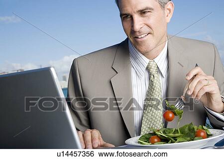 Stock Photograph - A businessman having lunch. Fotosearch