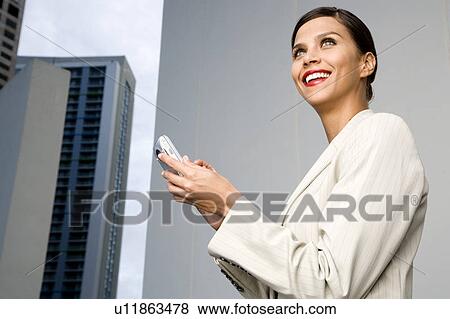 Stock Photo - A businesswoman reading a text message. Fotosearch