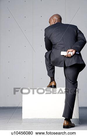 A businessman standing on a block View Large Photo Image Stock Image - A businessman standing on a block. Fotosearch
