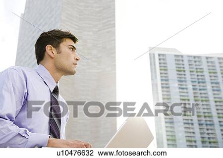Stock Image - A businessman using a laptop. Fotosearch