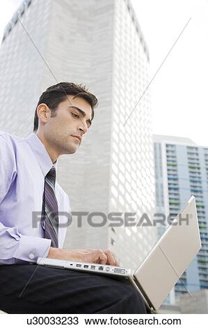 Stock Image - A businessman using a laptop. Fotosearch