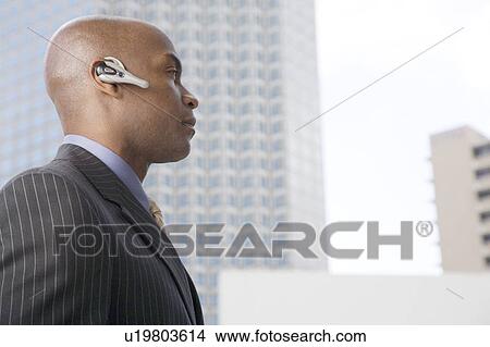 A businessman wearing a bluetooth headset View Large Photo Image Picture - A businessman wearing a bluetooth headset. Fotosearch