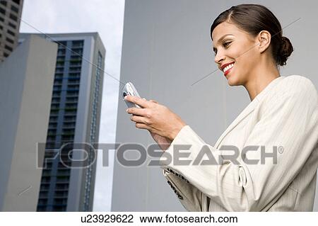 Stock Image - A businesswoman reading a text message. Fotosearch