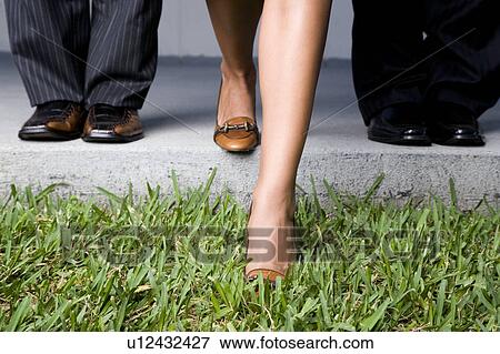 Stock Photo - Close up of three business colleagues' feet. Fotosearch