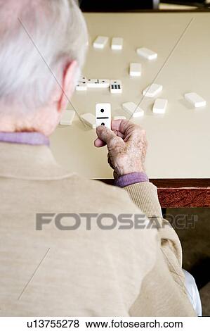 An elderly man playing dominoes View Large Photo Image Stock Photo - An elderly man playing dominoes. Fotosearch