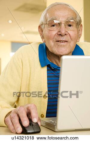 Stock Photo - An elderly man using a laptop. Fotosearch