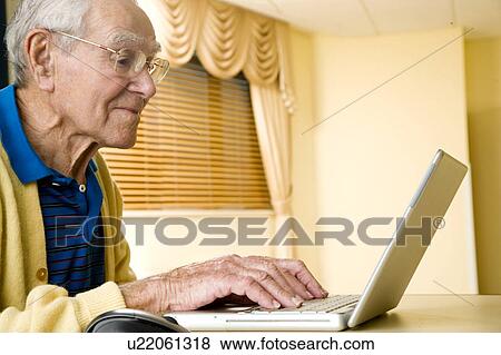 Stock Photo - An elderly man using a laptop. Fotosearch