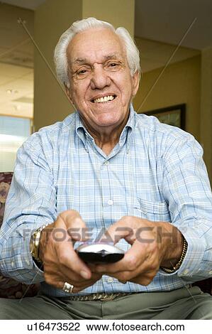 An elderly man using a TV remote control View Large Photo Image Stock Image - An elderly man using a TV remote control. Fotosearch