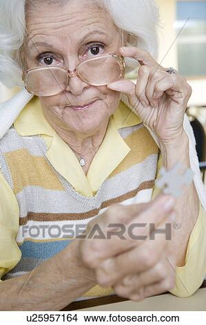 An elderly woman completing a jigsaw View Large Photo Image Picture - An elderly woman completing a jigsaw. Fotosearch