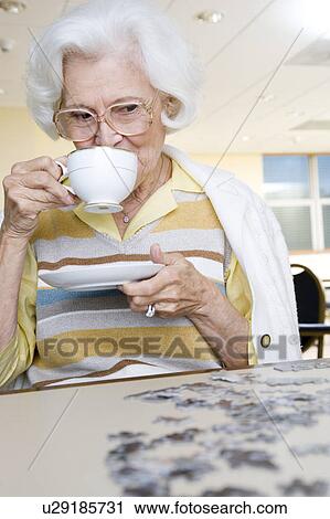 An elderly woman completing a jigsaw View Large Photo Image Stock Image - An elderly woman completing a jigsaw. Fotosearch