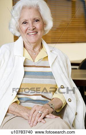 An elderly woman sitting in a chair View Large Photo Image Stock Image - An elderly woman sitting in a chair. Fotosearch