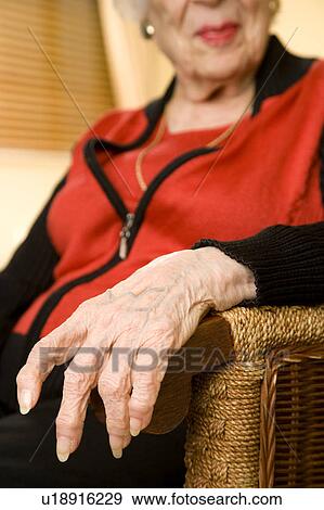 An elderly woman sitting in a chair View Large Photo Image Stock Photo - An elderly woman sitting in a chair. Fotosearch