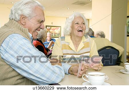 Two residents in a retirement home playing cards View Large Photo Image Stock Photo - Two residents in a retirement home playing cards. Fotosearch