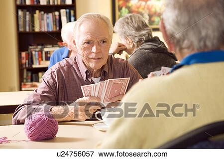 Two residents in a retirement home playing cards View Large Photo Image Stock Photo - Two residents in a retirement home playing cards. Fotosearch