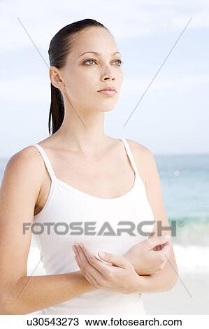 Stock Image - A young woman doing yoga on the beach. Fotosearch