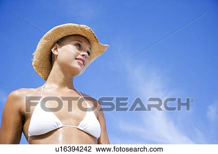 Stock Image - A young woman in bikini and hat . Fotosearch