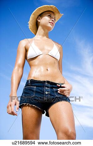 A young woman in bikini and shorts View Large Photo Image Picture - A young woman in bikini and shorts . Fotosearch