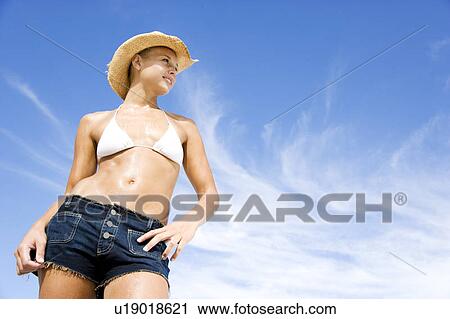 A young woman in bikini, shorts and hat View Large Photo Image Stock Image - A young woman in bikini, shorts and hat . Fotosearch