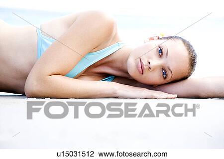 A young woman laying on the beach View Large Photo Image Stock Image - A young woman laying on the beach . Fotosearch