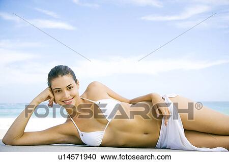 A young woman lying on the beach View Large Photo Image Stock Image - A young woman lying on the beach. Fotosearch