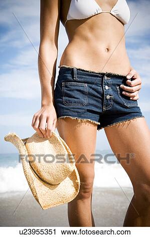 A young woman on the beach bikini and shorts View Large Photo Image Stock Image - A young woman on the beach bikini and shorts. Fotosearch