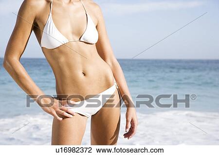 A young woman on the beach in bikini View Large Photo Image Stock Image - A young woman on the beach in bikini . Fotosearch