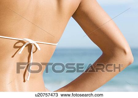 A young woman on the beach rear view View Large Photo Image Stock Image - A young woman on the beach rear view. Fotosearch