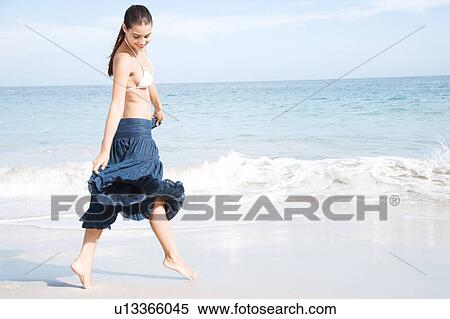 A young woman paddling on the beach View Large Photo Image Stock Photography - A young woman paddling on the beach . Fotosearch