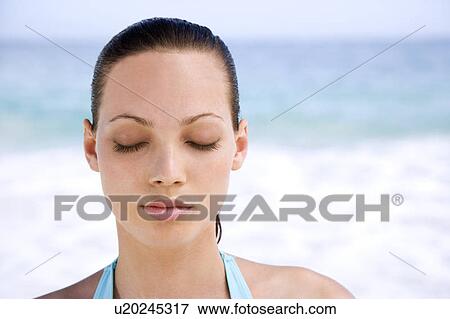 Portrait young woman on the beach with eyes closed View Large Photo Image Stock Photo - Portrait young woman on the beach with eyes closed. Fotosearch