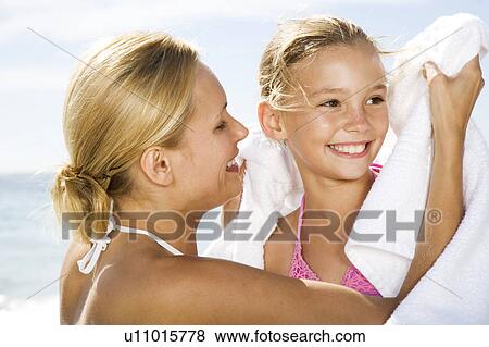 A mother drying her daughter with a towel on the beach View Large Photo Image Stock Photo - A mother drying her daughter with a towel on the beach. Fotosearch