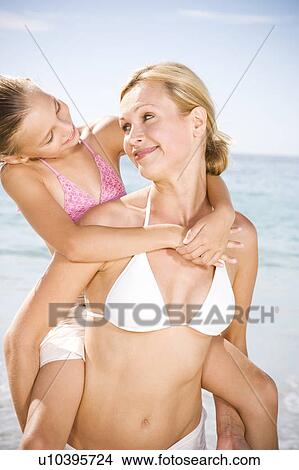 A mother giving her daughter a piggy back View Large Photo Image Picture - A mother giving her daughter a piggy back. Fotosearch