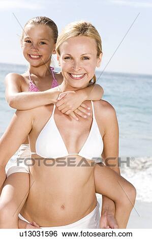 A mother giving her daughter a piggy back View Large Photo Image Stock Photograph - A mother giving her daughter a piggy back. Fotosearch