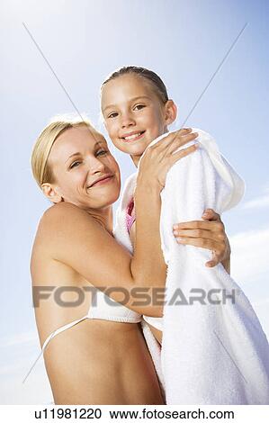 Stock Image - A mother hugging her daughter on the beach. Fotosearch