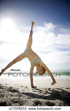 A young girl cartwheeling on the beach View Large Photo Image Stock Image - A young girl cartwheeling on the beach. Fotosearch
