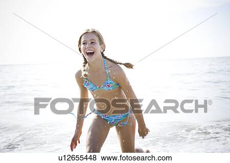 Stock Photo - A young girl laughing on the beach. Fotosearch