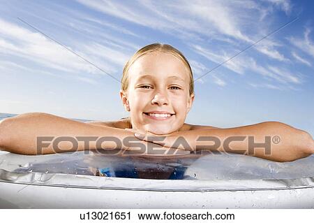 A young girl laying on a lilo View Large Photo Image Stock Image - A young girl laying on a lilo. Fotosearch