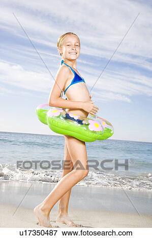 A young girl on the beach with a rubber ring View Large Photo Image Stock Photo - A young girl on the beach with a rubber ring. Fotosearch