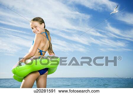 A young girl on the beach with rubber ring View Large Photo Image Stock Image - A young girl on the beach with rubber ring. Fotosearch