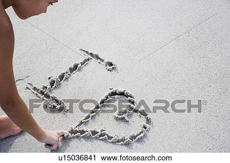 A young girl writing in the sand View Large Photo Image Stock Image - A young girl writing in the sand. Fotosearch