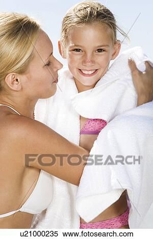 Stock Photography - Mother drying her daughter on the beach. Fotosearch