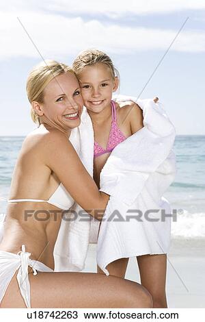 Mother embracing daughter on the beach View Large Photo Image Stock Image - Mother embracing daughter on the beach. Fotosearch