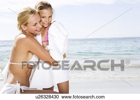 Mother embracing daughter on the beach View Large Photo Image Stock Image - Mother embracing daughter on the beach. Fotosearch