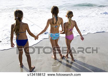 Stock Image - Three young girls on the beach. Fotosearch