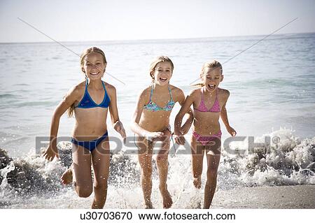 Three young girls running out of the sea View Large Photo Image Stock Image - Three young girls running out of the sea. Fotosearch